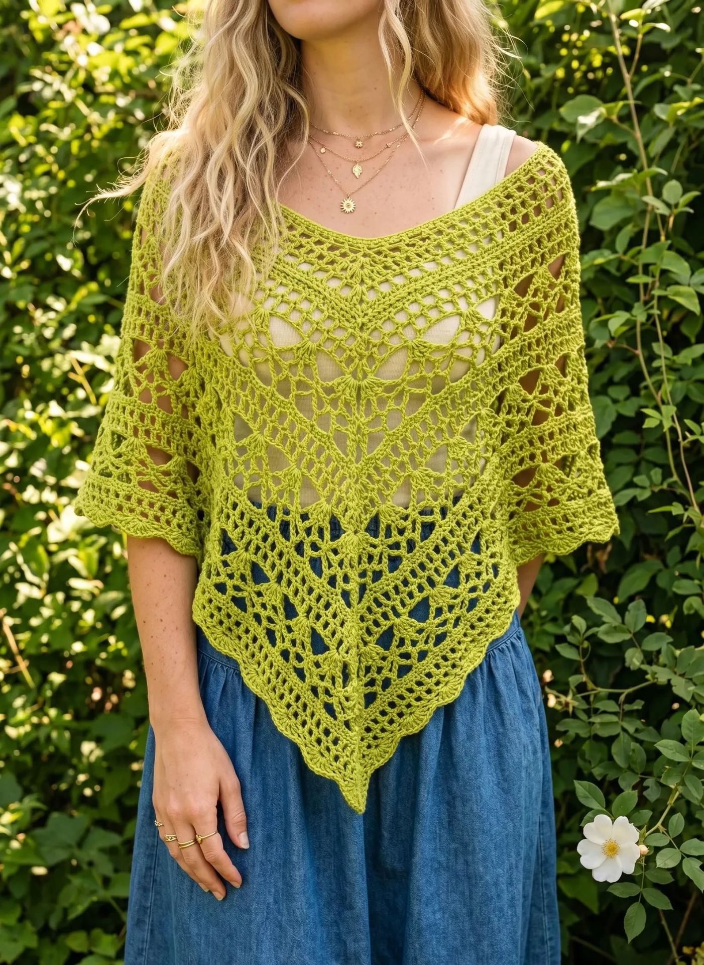 Green lace crochet poncho worn in a garden